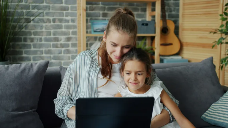 A mother and daughter looking at a laptop together