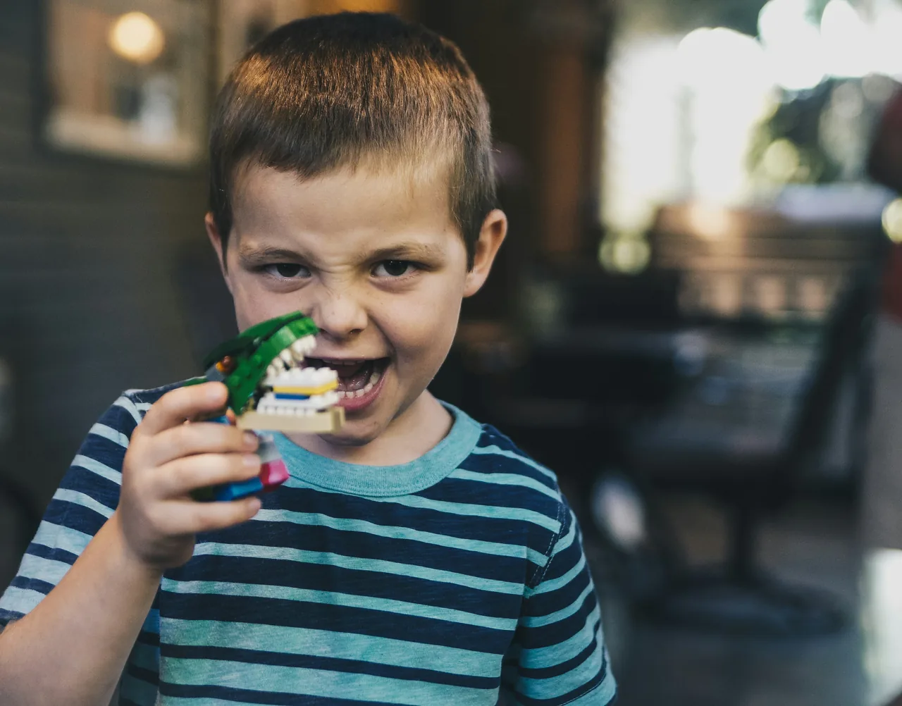 Boy in a striped shirt holding a toy